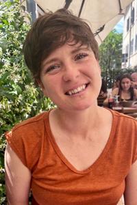 A smiling white woman wearing an orange shirt